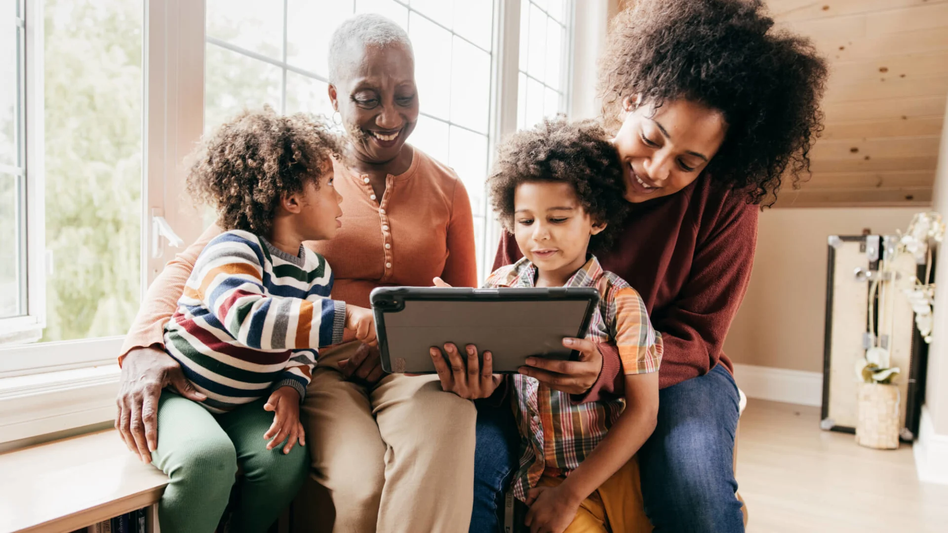 Multi-generational family smiling using tablet