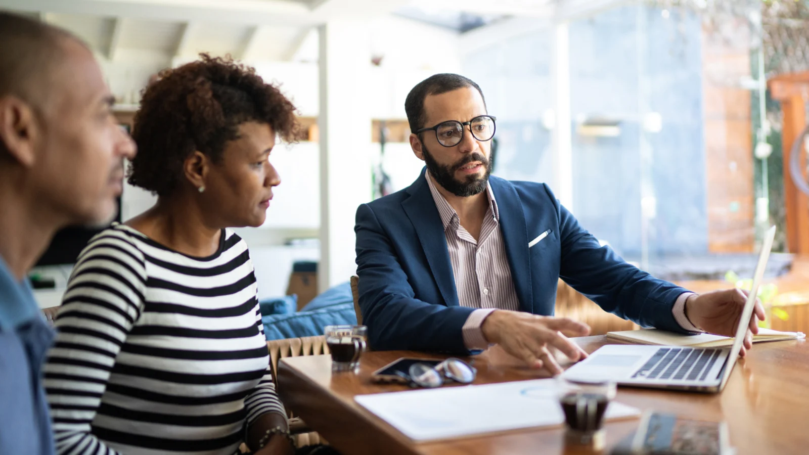 Find out more about life insurance solutions for foreign nationals - Financial professional looking at his laptop with his clients