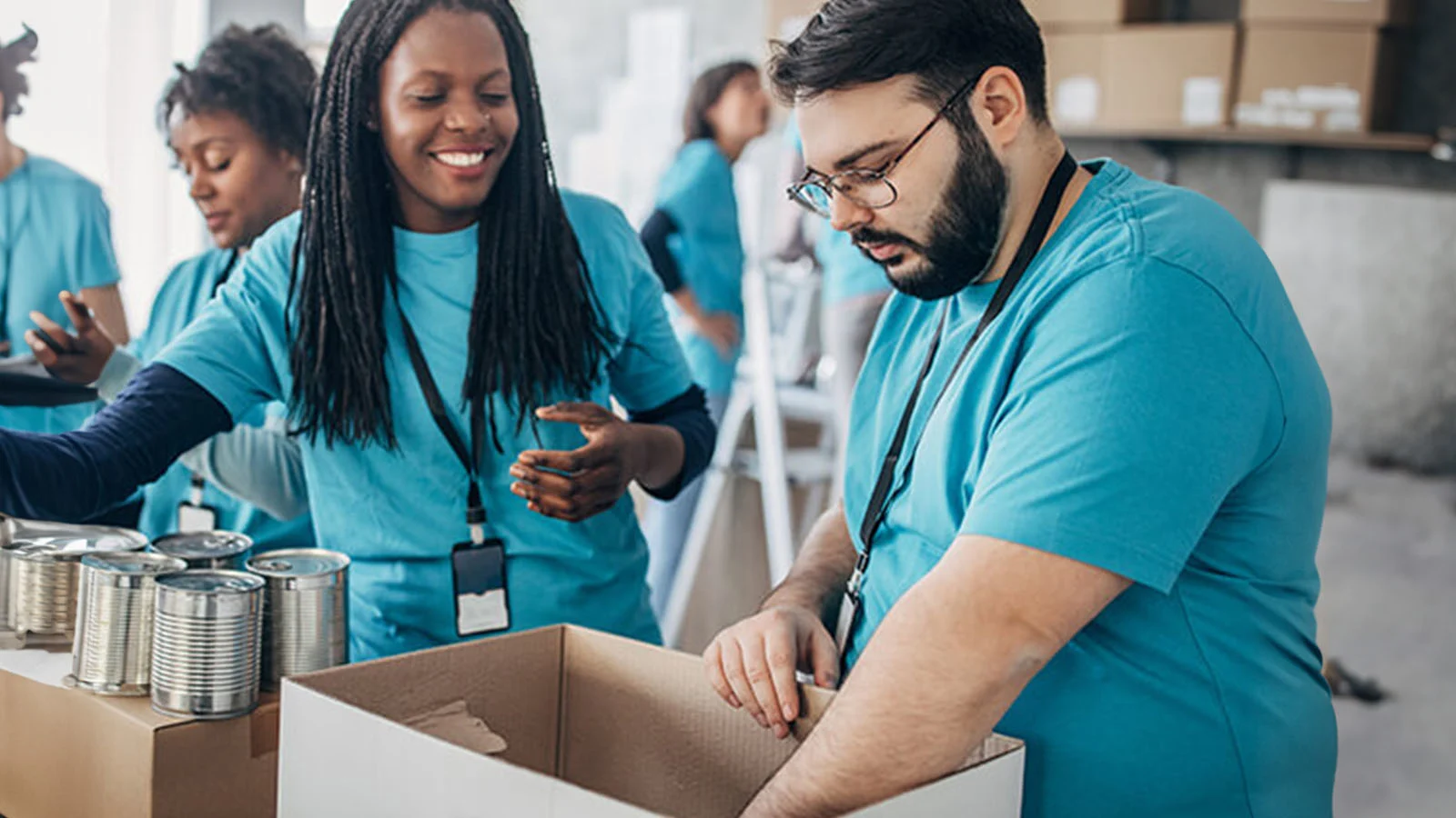 New Era, New Values - 2 coworkers packing boxes for charity