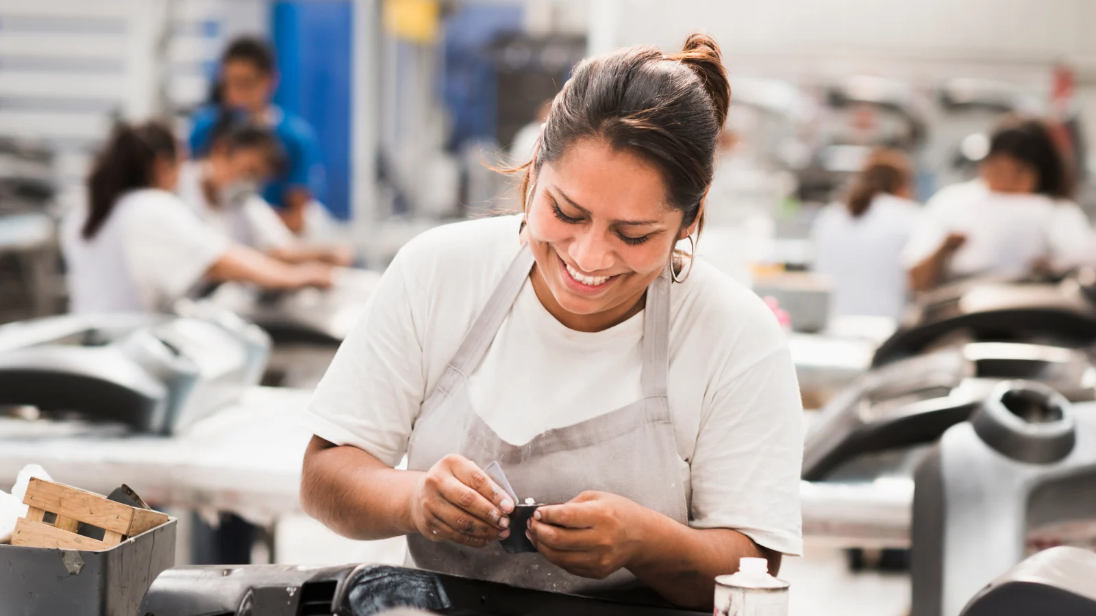 Female worker smiling in a manufacturing plant