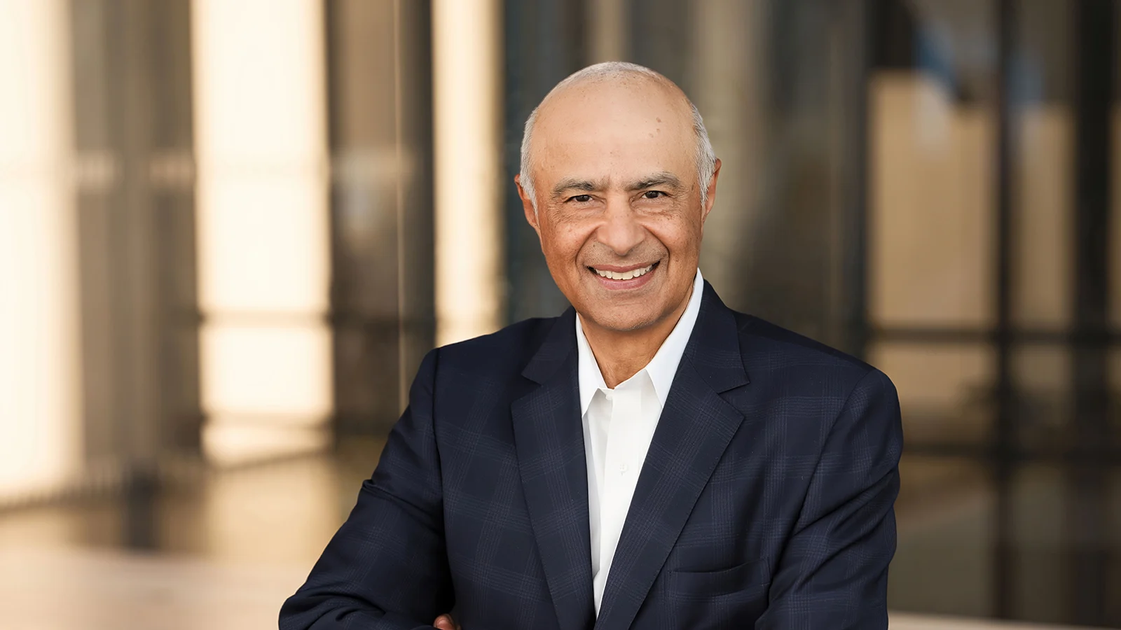 Portrait of Vikram Malhotra in a dark blue suit jacket and white shirt.