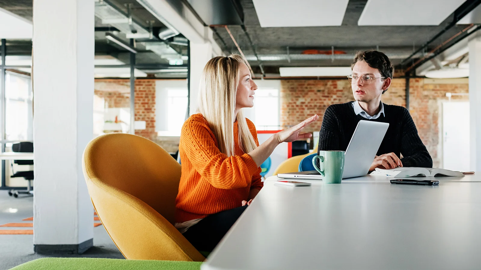 Two coworkers talking to each other in the office