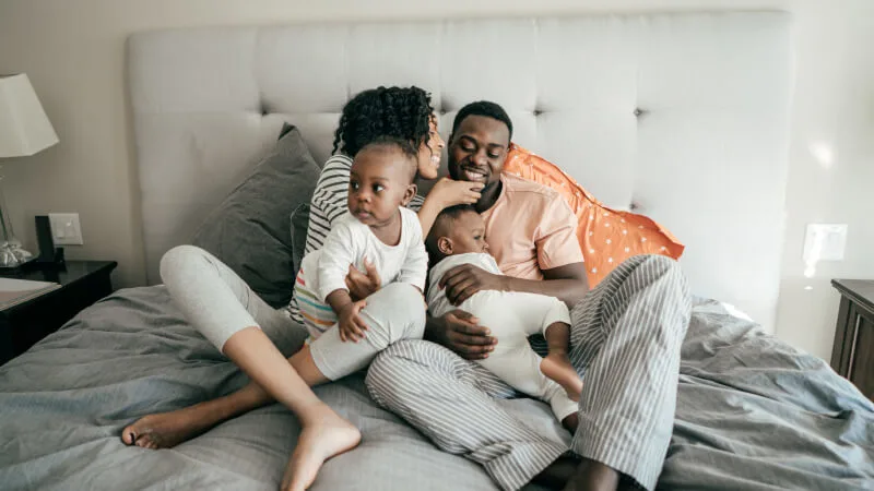 An individual or family plan - Happy family relaxing in bed