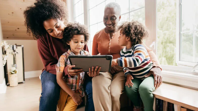 Life insurance - Multigenerational family smiling using tablet