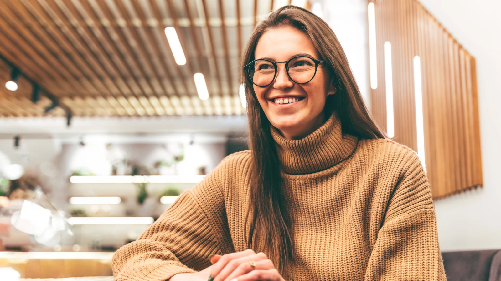 Seeing Clearly​: The role of vision benefits in supporting workforce well-being - Young business woman sitting at the cafe table