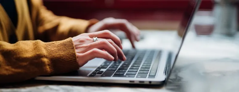 close up of a person typing on a laptop