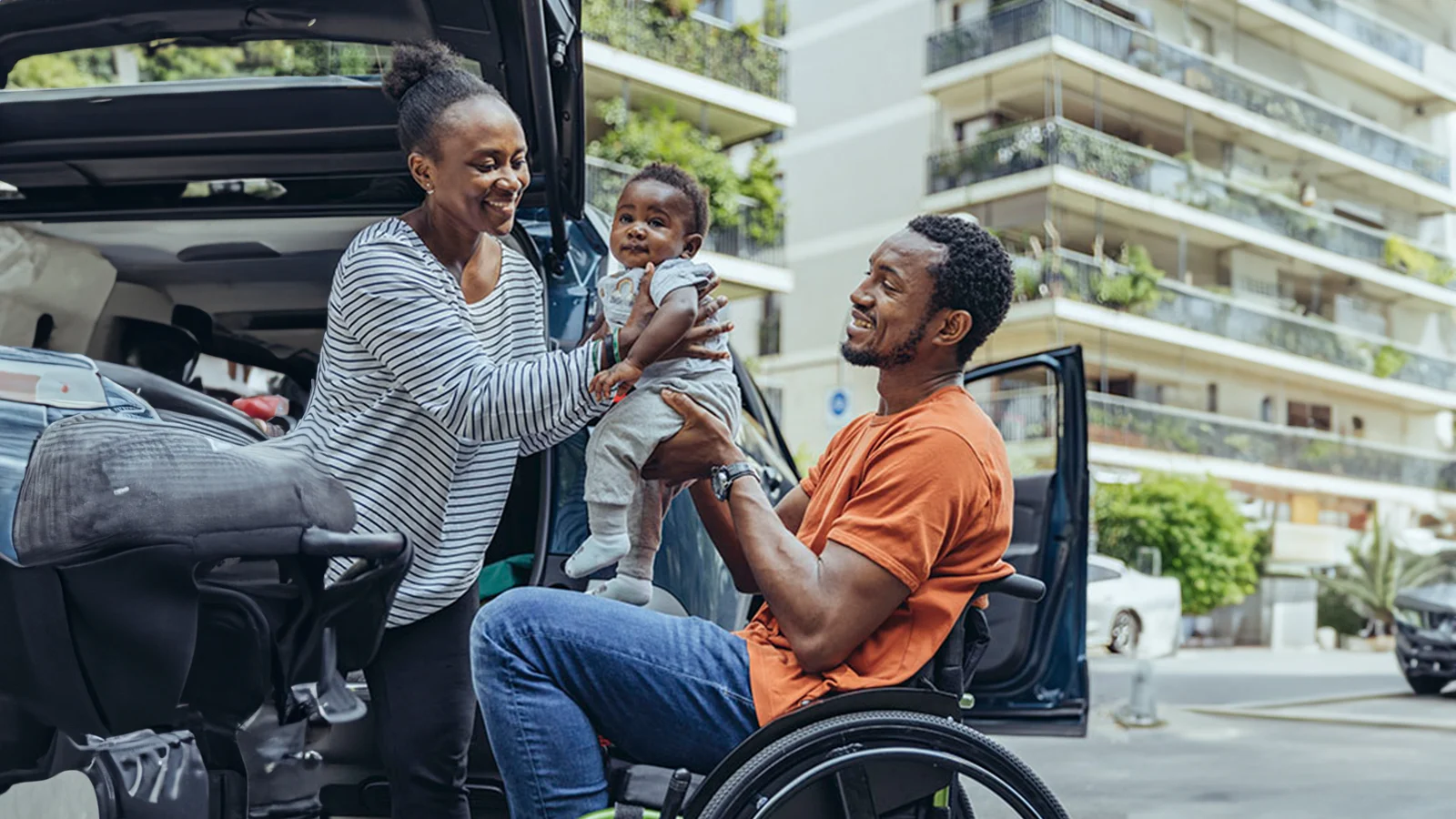 Future accommodations - Mother handing their baby boy to the father sitting in a wheelchair