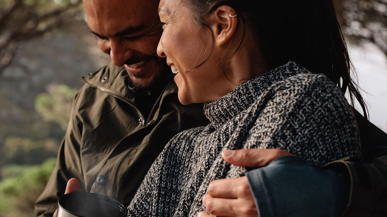 Smiling couple outdoors with coffee