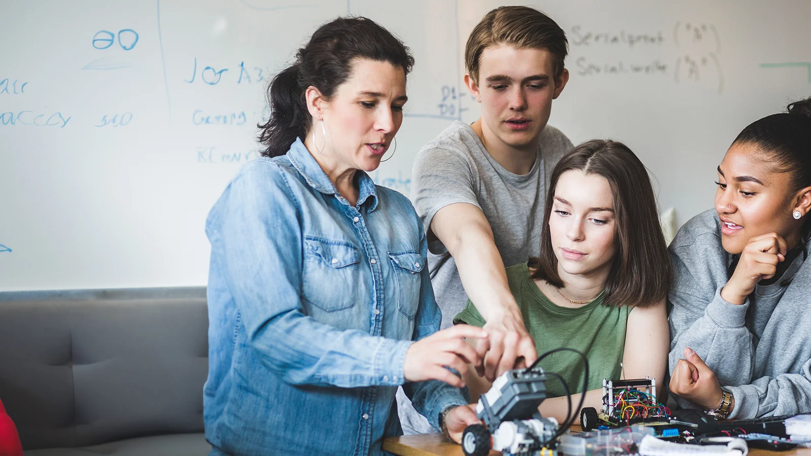 Teacher examining robot with students