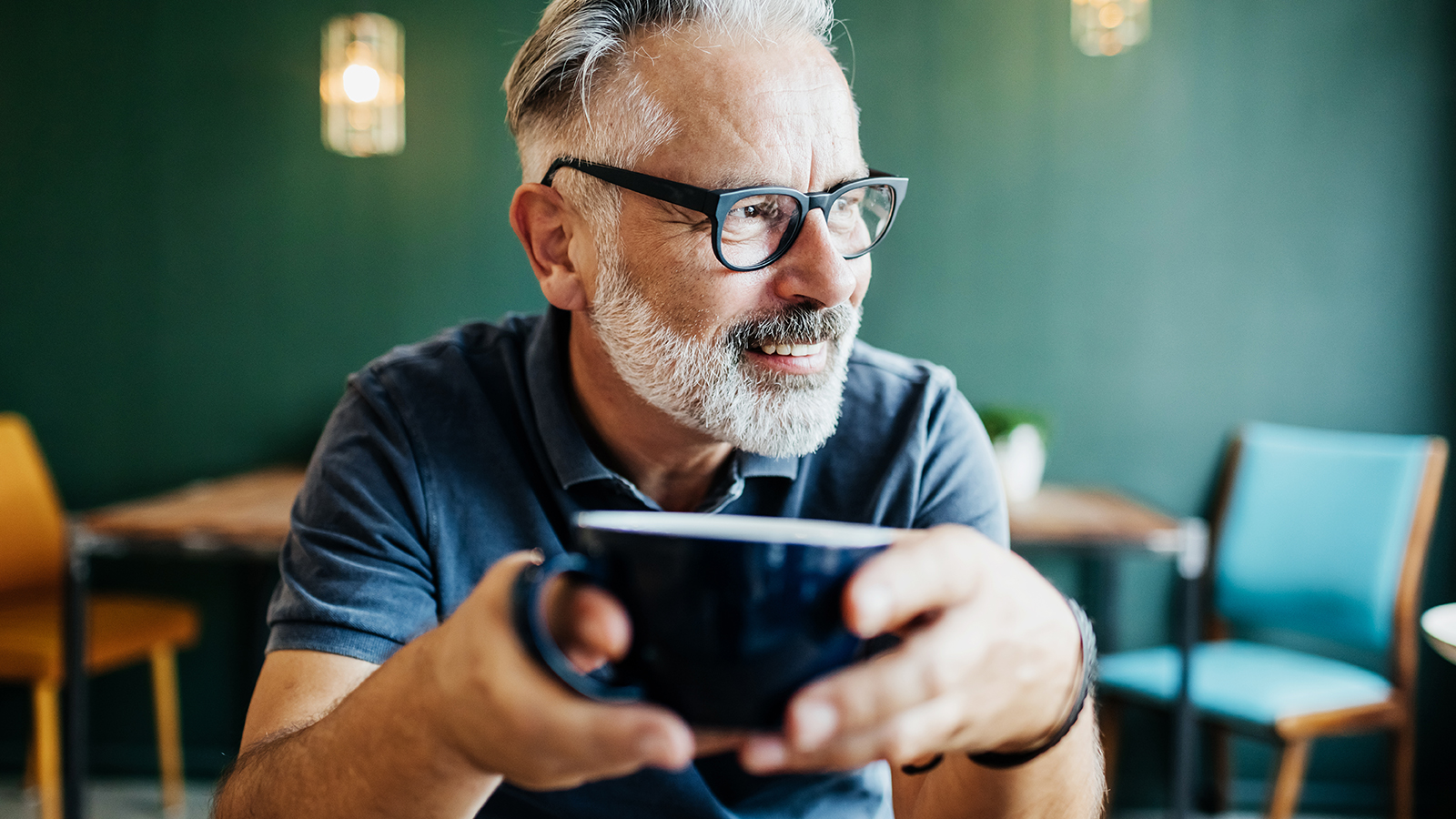 Older man smiling and holding mug