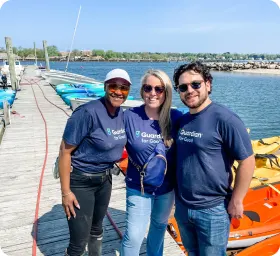 2,300+ - Three people stand on a boat dock in matching Guardian t-shirts