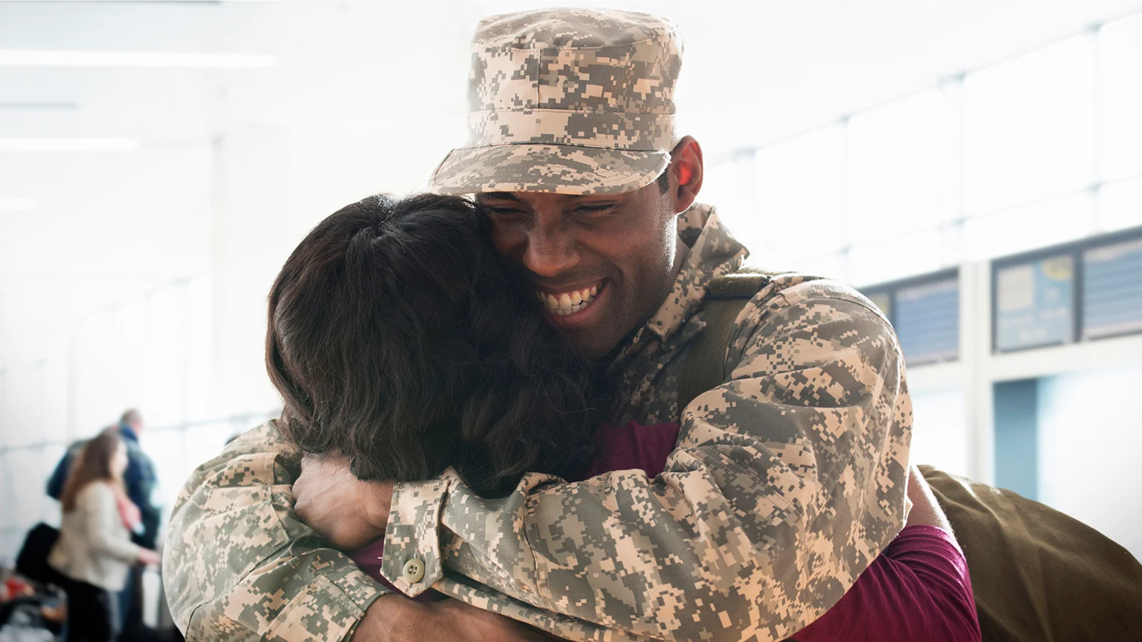 man in military hugging spouse