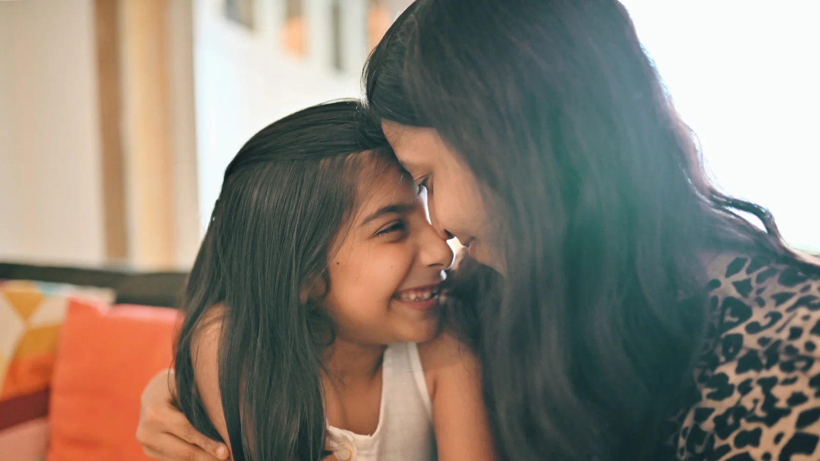 Support employee financial and mental well-being  - Young mother and daughter embracing at home.
