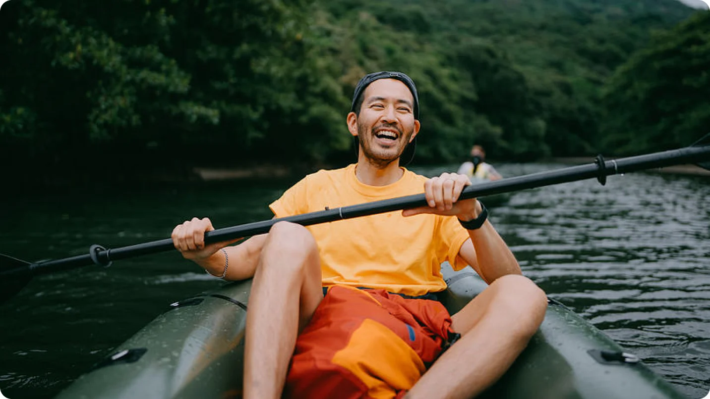 Navigating your mental health - Man in an inflatable kayak paddling down a river