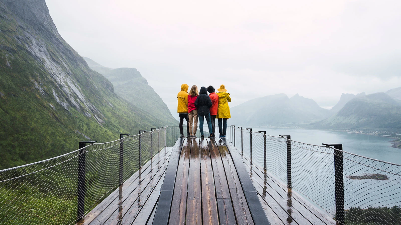 Group-of-people-in-raincoats-looking-out-at-the-water