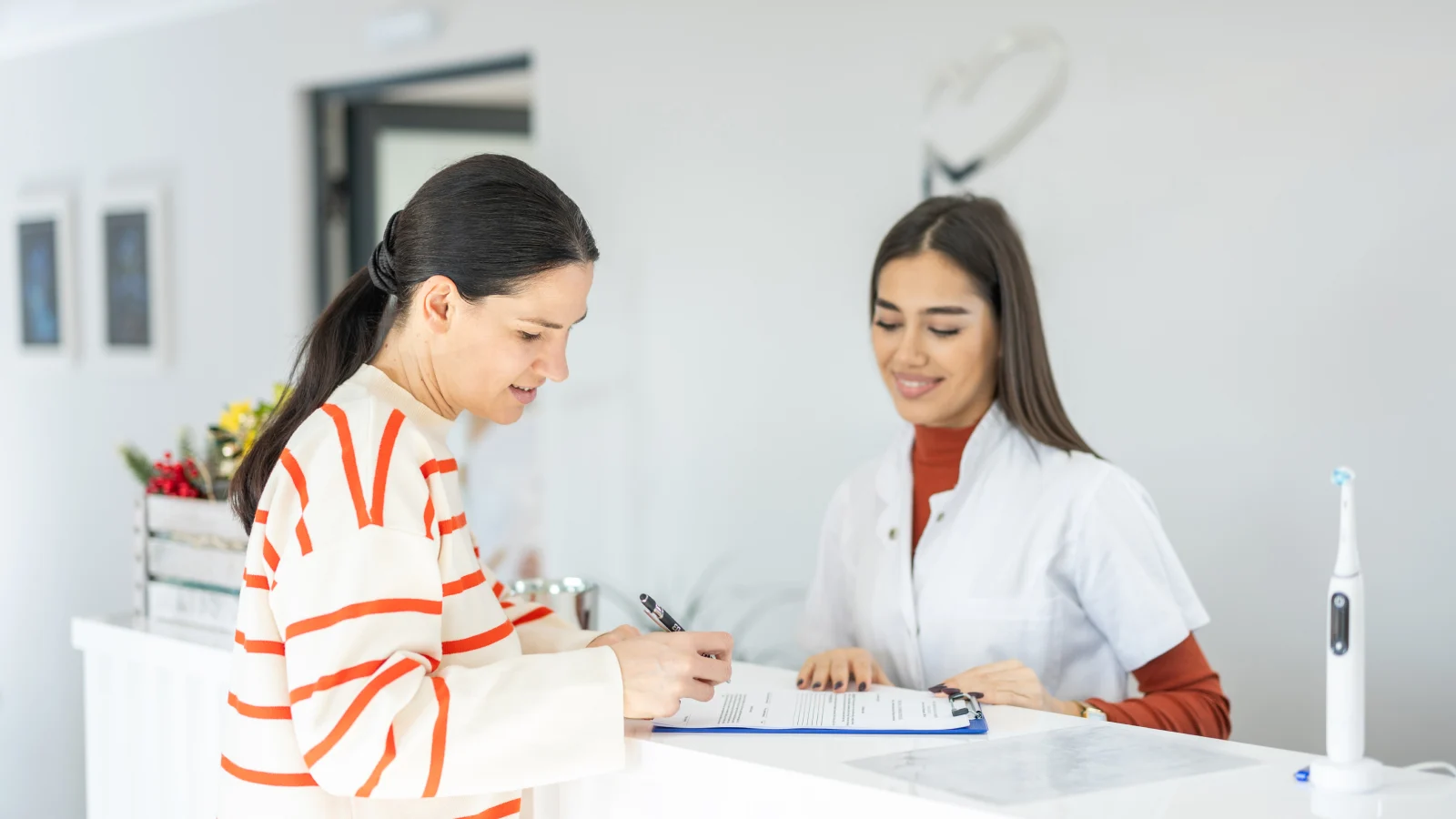 woman-checking-in-with-receptionist-at-dental-office