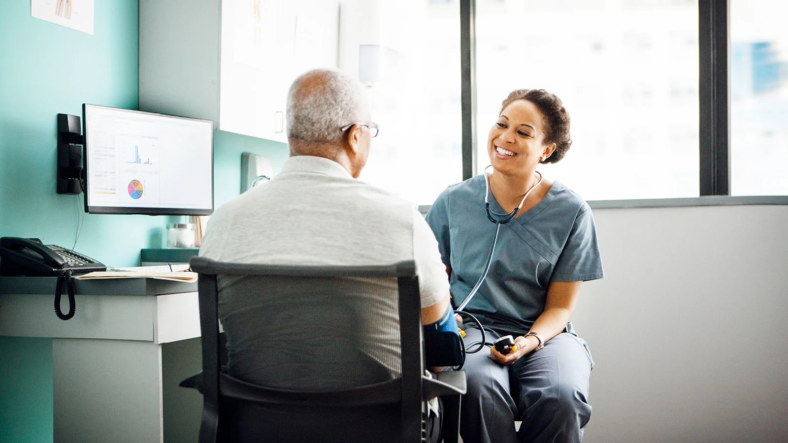 The benefits of health screenings: How they can help protect your health and finances - Patient-talks-with-doctor-in-exam-room