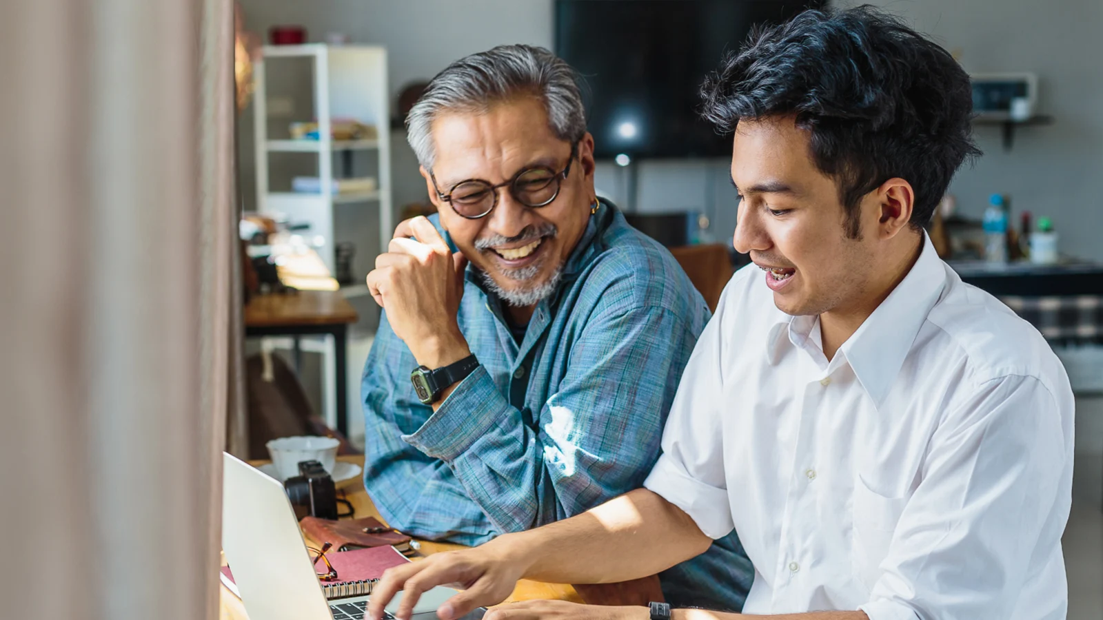 Father and son working on a laptop at home