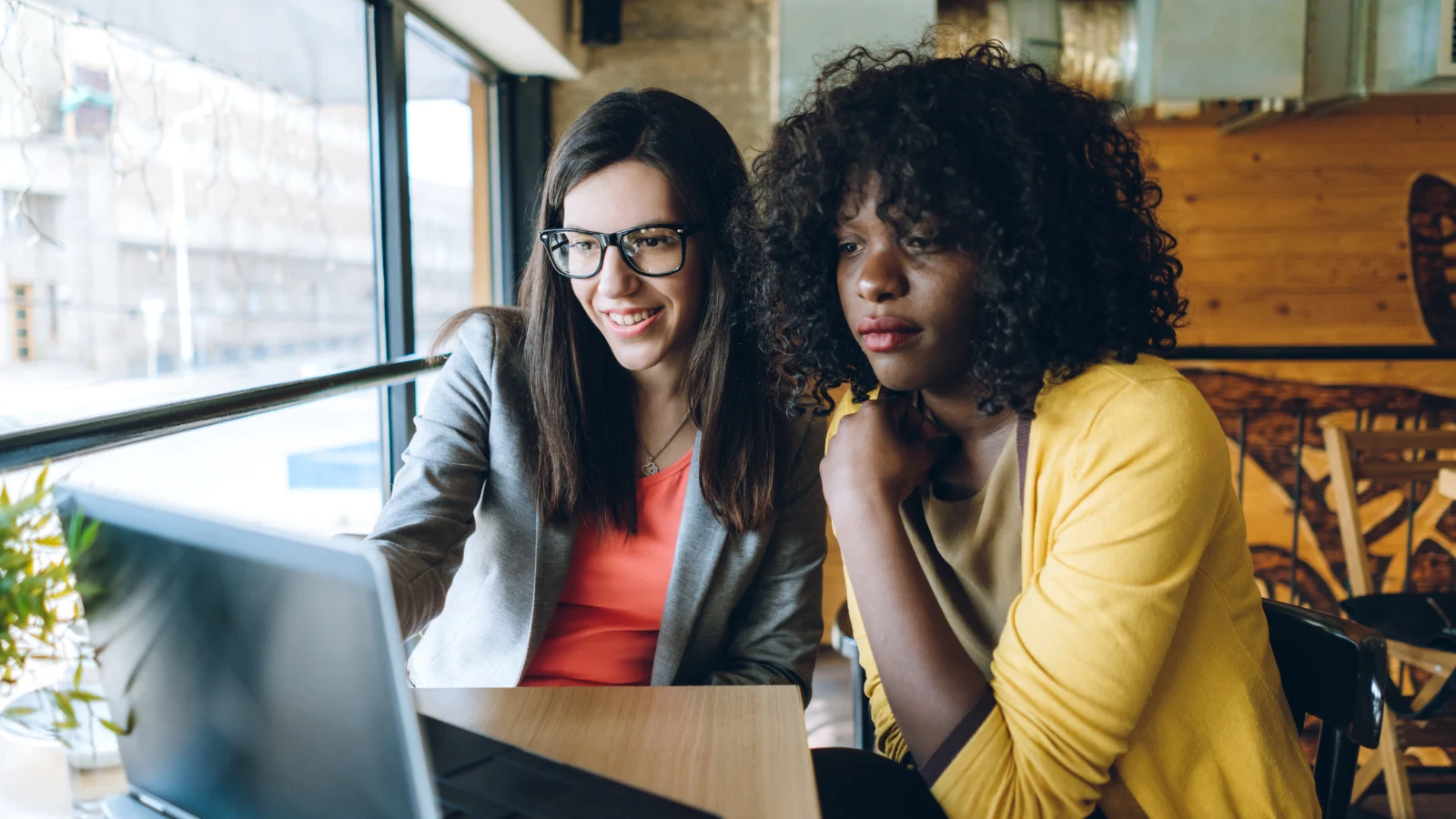 Leave time available - Two female colleagues looking at a screen together.