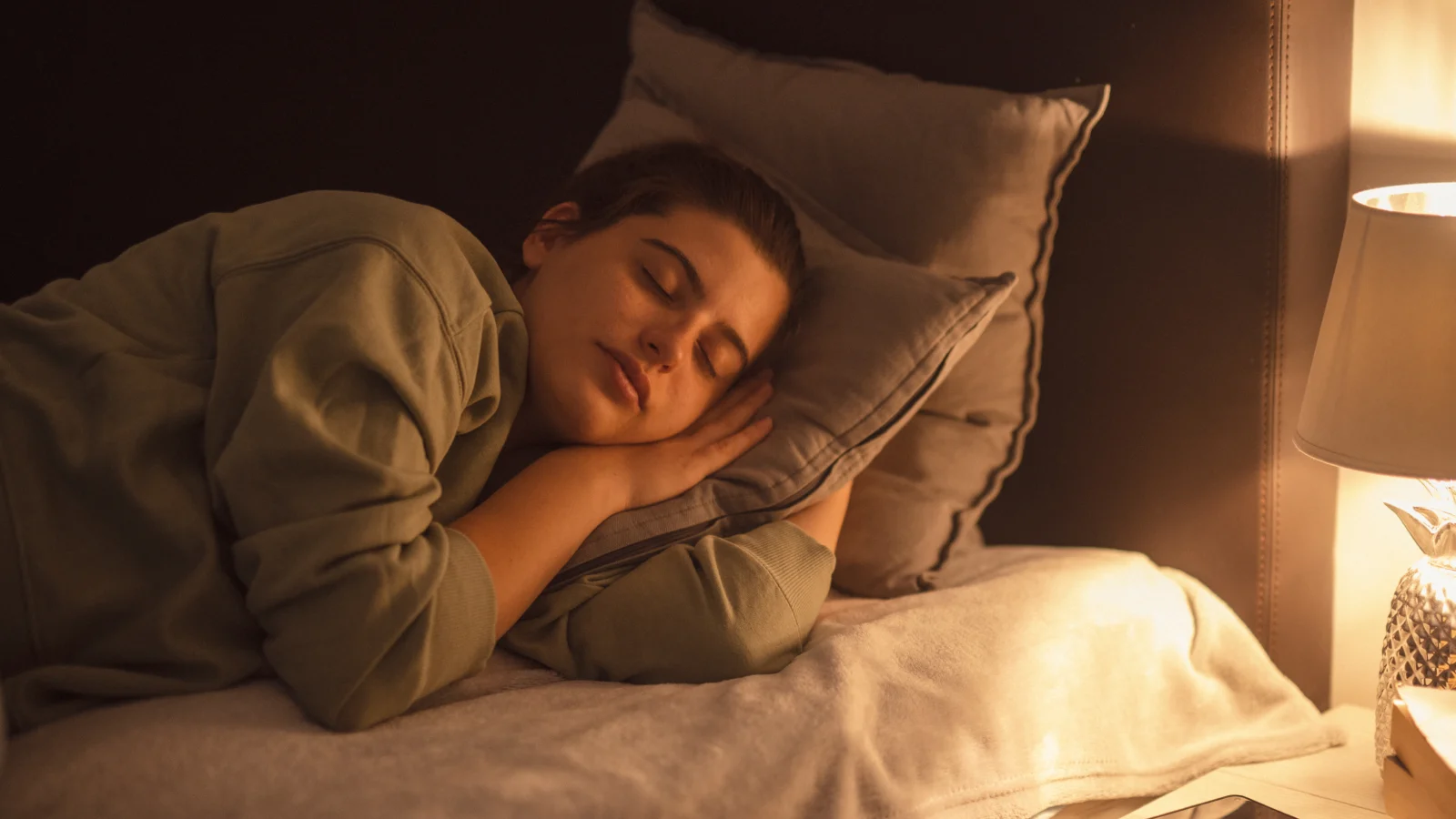 Lamp illuminating sleeping woman at night