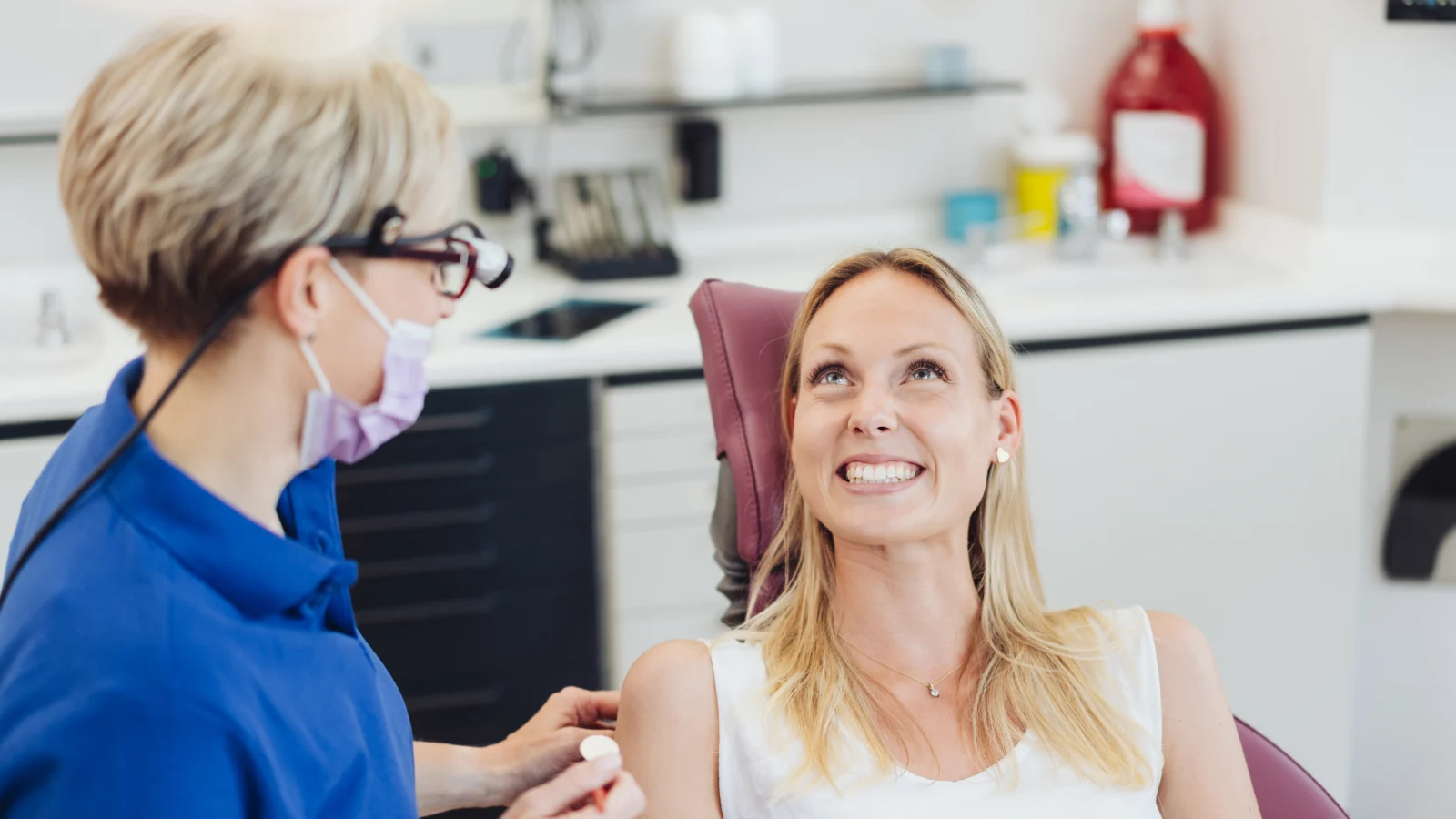 A strong, far-reaching network  - Dentist and patient in chair smiling at one another.