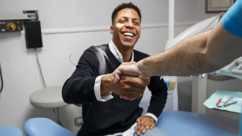 How can I reach new dental patients? - Patient shaking hands with dentist