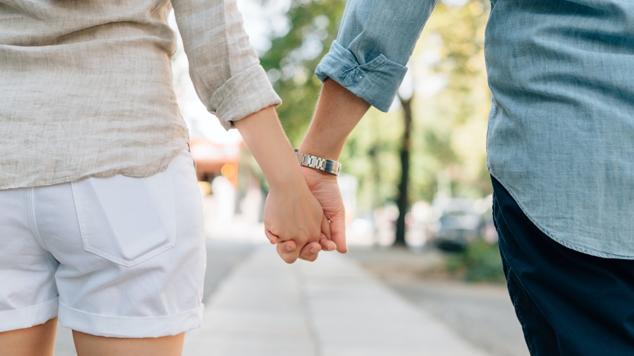 Ein Mann und eine Frau spazieren Hand in Hand