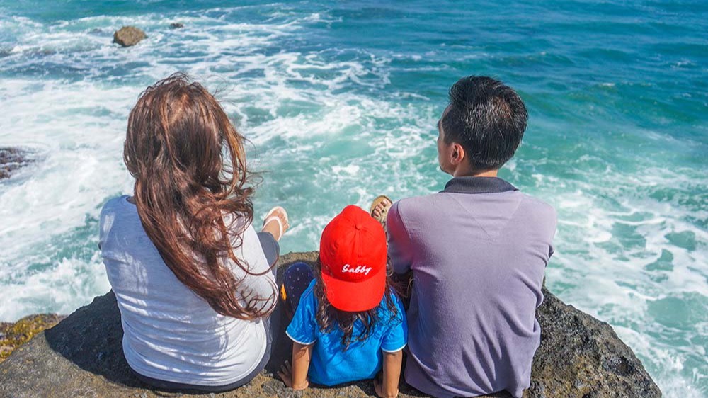 Eine Familie sitzt im Urlaub am Meer