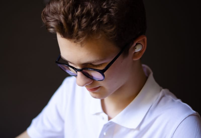 Ein Junge trägt In-Ear Headphones