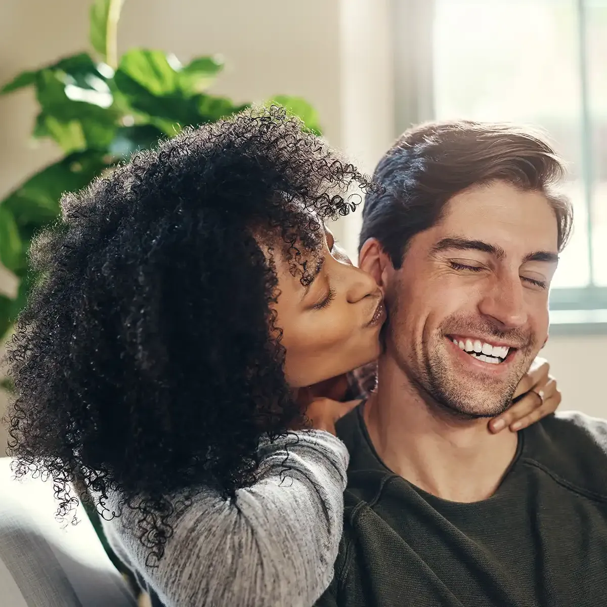 Woman kissing smiling man's cheek.