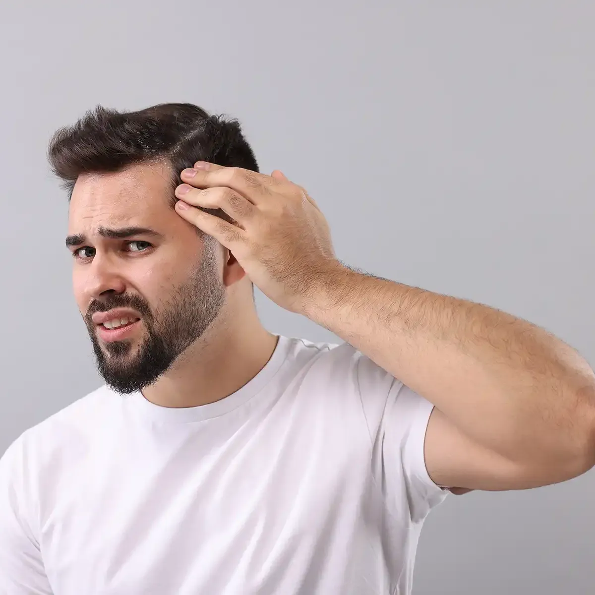 man inspecting his receding hair line