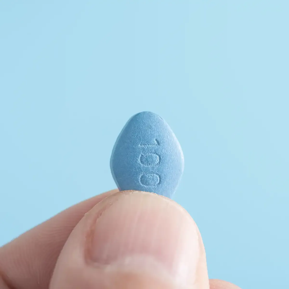 man holding a blue Viagra pill