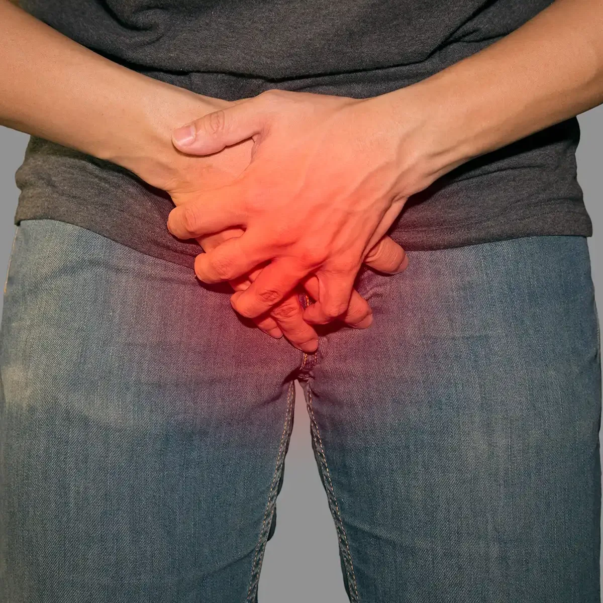 man with hands in front of his crotch, showing pain.