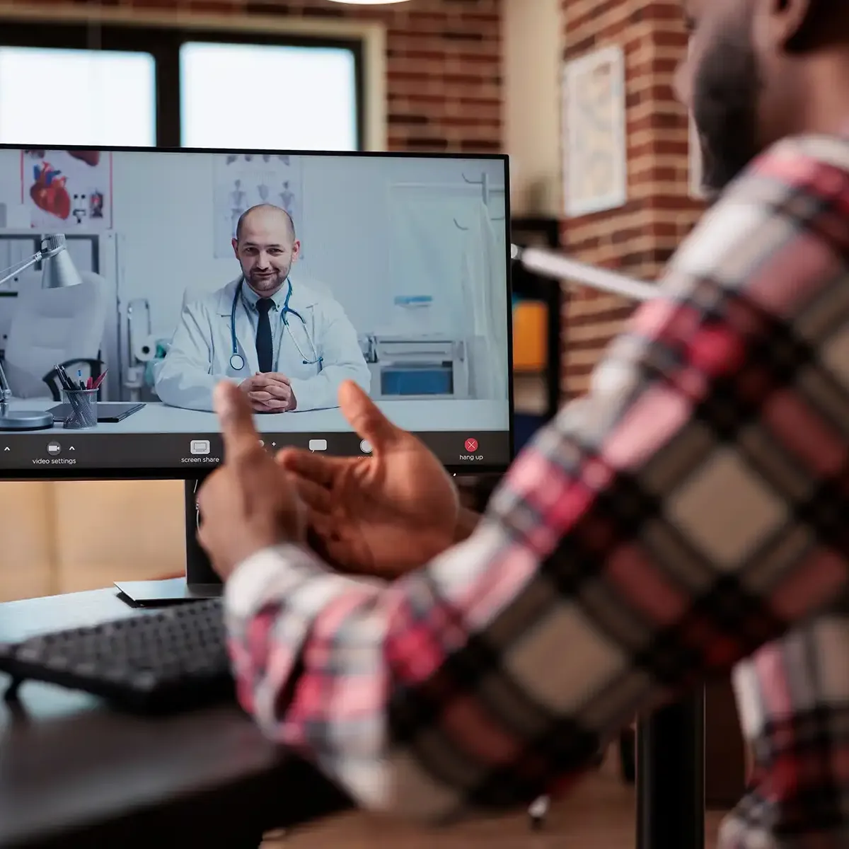 man on telehealth video call with a doctor