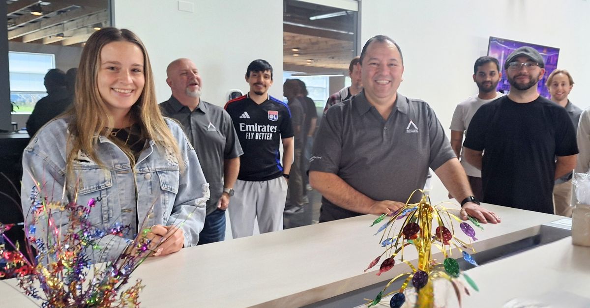 Company members standing around a counter.