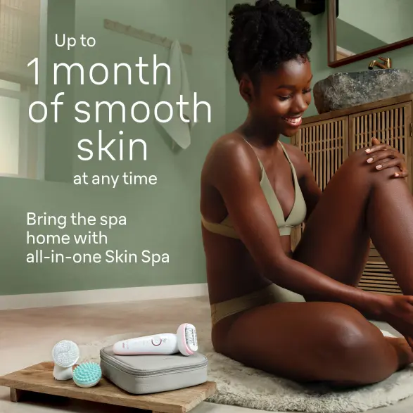 Woman sitting in the bathroom and smiling, epilation device beside her