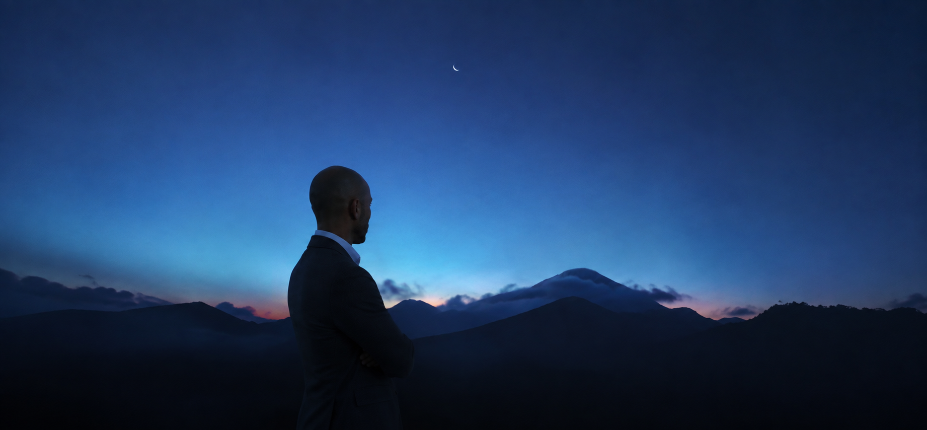 Person vor einer blauen Berglandschaft bei Nacht