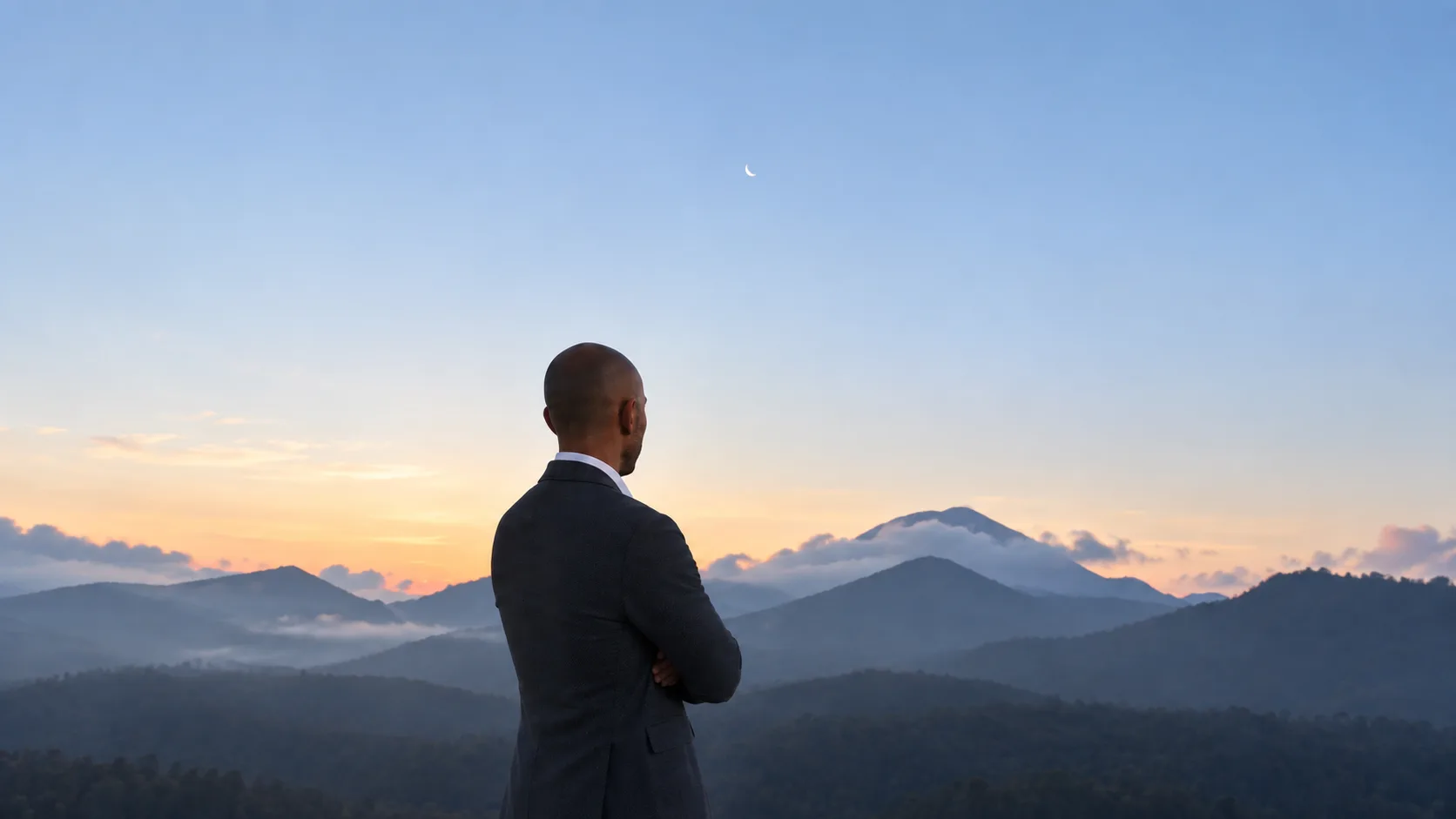 Person vor einer Berglandschaft in der Daemmerung