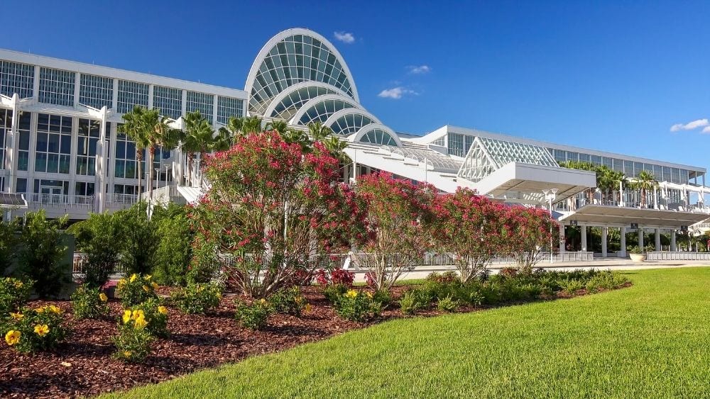 The Orange County Convention Center, a modern building with lots of windows and plenty of landscaping lining the front.