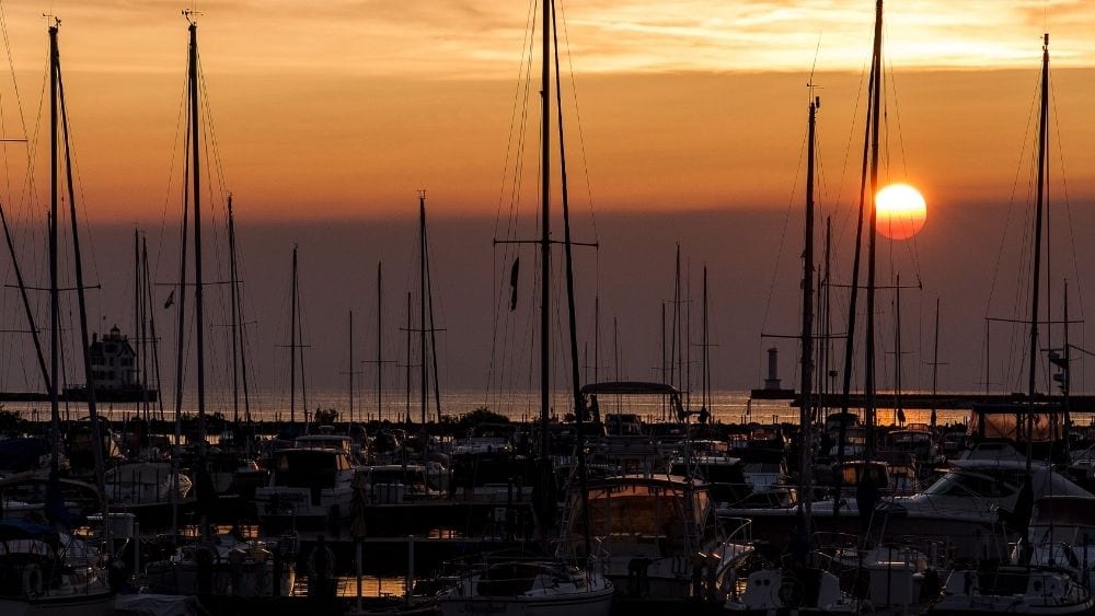 Boats at a dock at sunset.