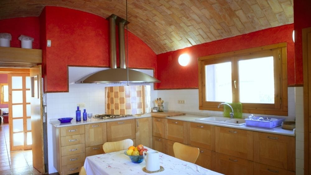 A red and brown kitchen with a barrel ceiling.
