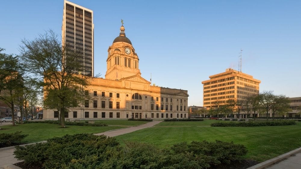 Fort Wayne’s courthouse and lawn, illuminated in the afternoon sun on a clear day.