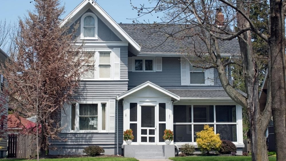 Large home with grey wood siding, white trim, and a covered porch.