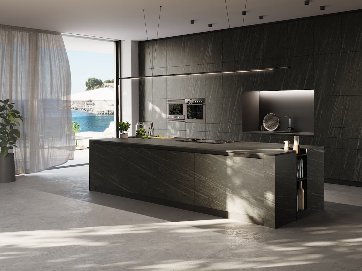 Kitchen shot, with dark sintered stone island and sintered stone wall, with large window wall on the side.