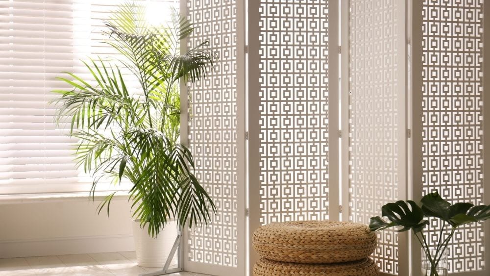 Wooden room divider with light filtering through.