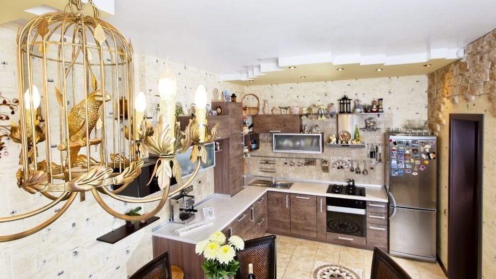 Close-up of a chandelier made to look like a golden crow in a bird cage in a kitchen