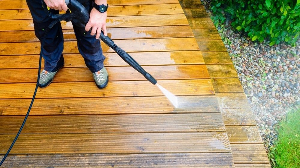 Someone power washing a deck.