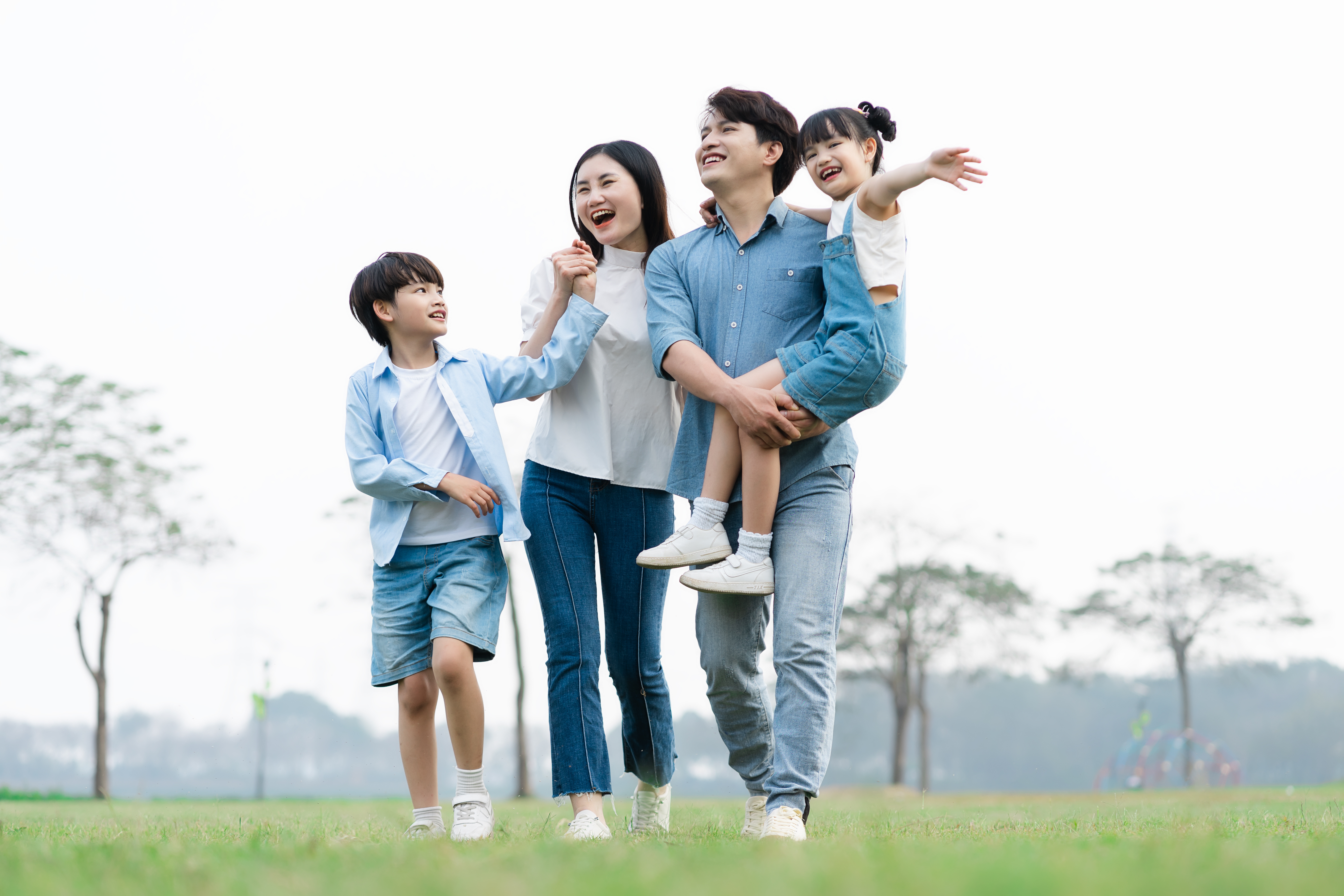 Vietnamese family of husband, wife, boy and girl, walking in a park