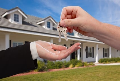 handing-over-the-house-keys-in-front-of-a-beautiful-new-home
