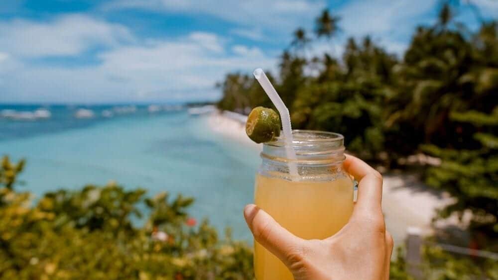 hand holding a tropical drink